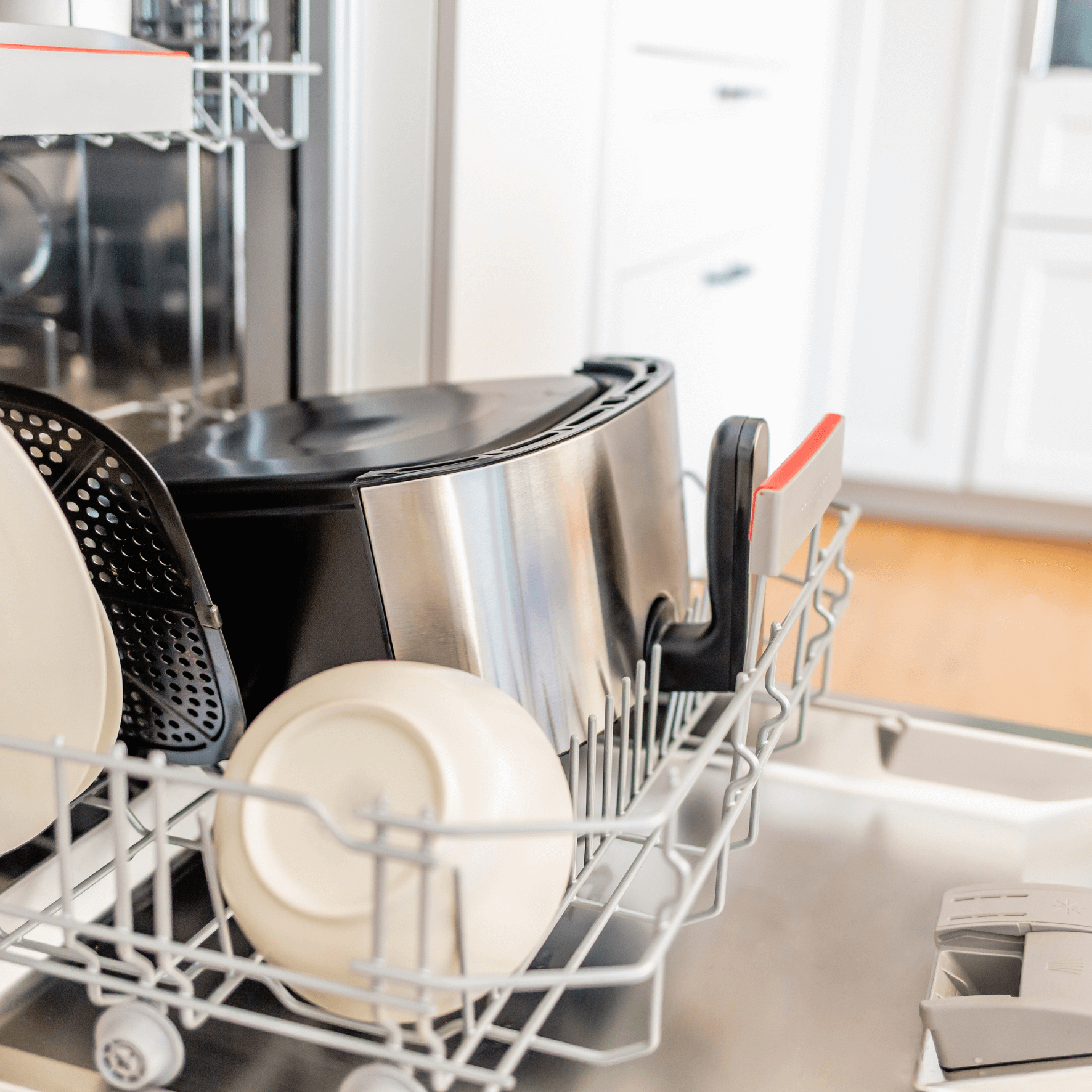 Heißluftfritteuse Steba HF8000 im Geschirrspüler, umgeben von Geschirr. Sichtbare Edelstahl- und schwarze Elemente.