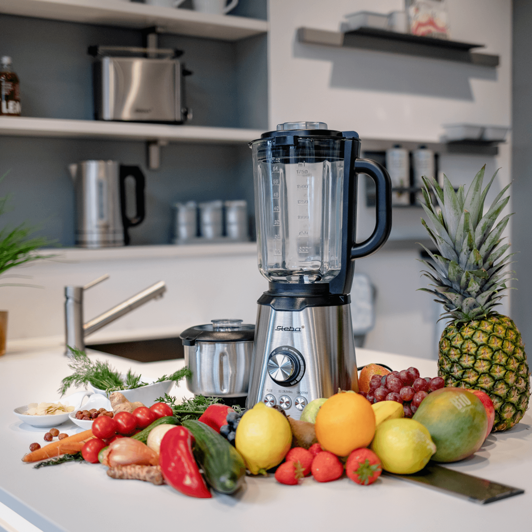 MX4 Plus Standmixer von Steba mit transparentem Behälter, umgeben von frischem Obst und Gemüse auf einer modernen Küchenarbeitsplatte.