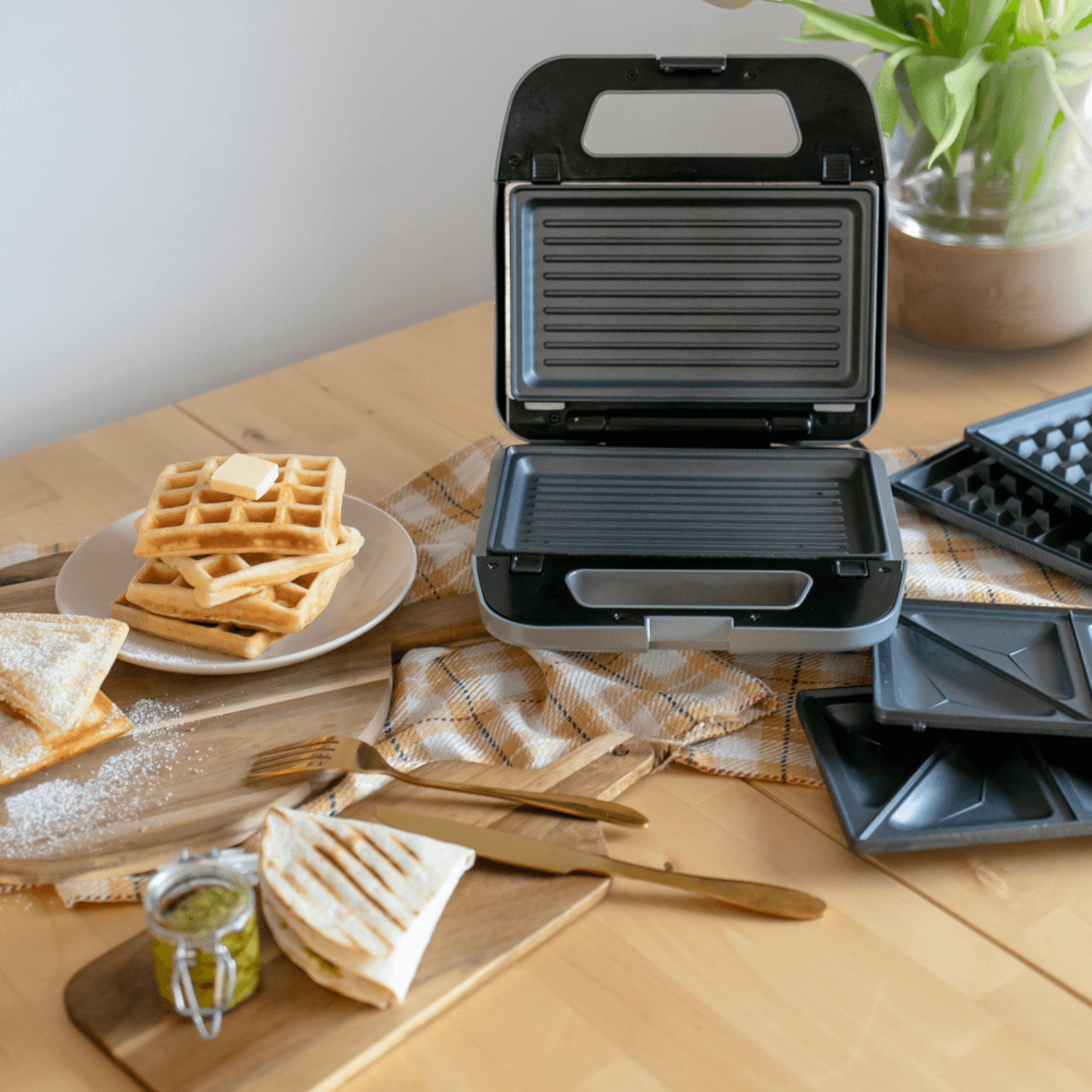 Multi-Snack Maker von Steba mit offenen Platten, um Waffeln und Sandwiches zuzubereiten. Zubehörteile sind sichtbar.