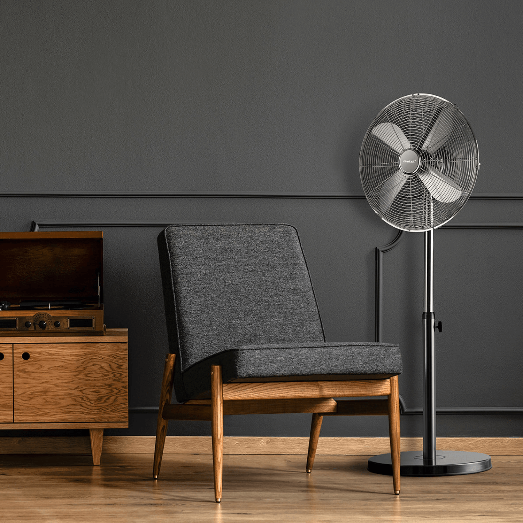 Standventilator von Steba mit Metallgitter, verstellbarem Standfuß und modernem Design, platziert neben einem Stuhl und einem Holzschrank.
