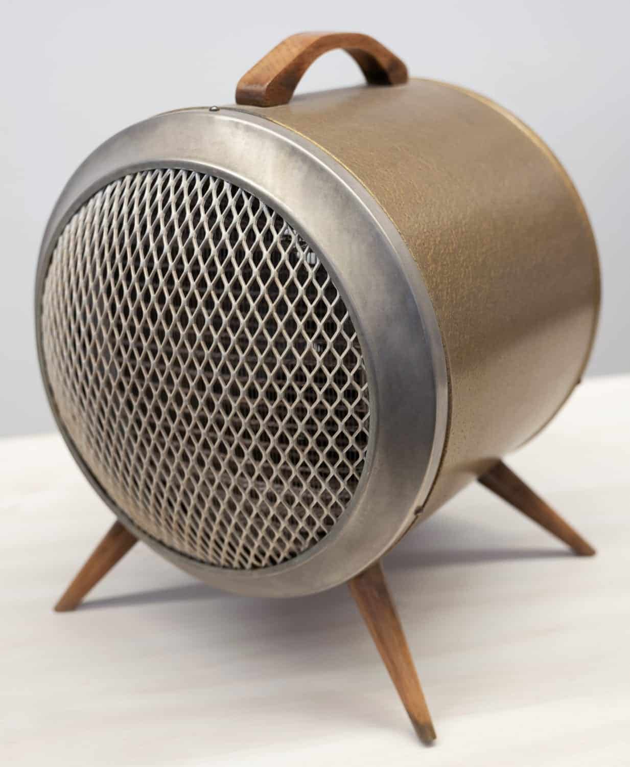 Retro Design-Heizgerät aus den 1950er Jahren mit runder Form, Metallgitter und Holzgriffen. Stabile Holzfüße für sicheren Stand.