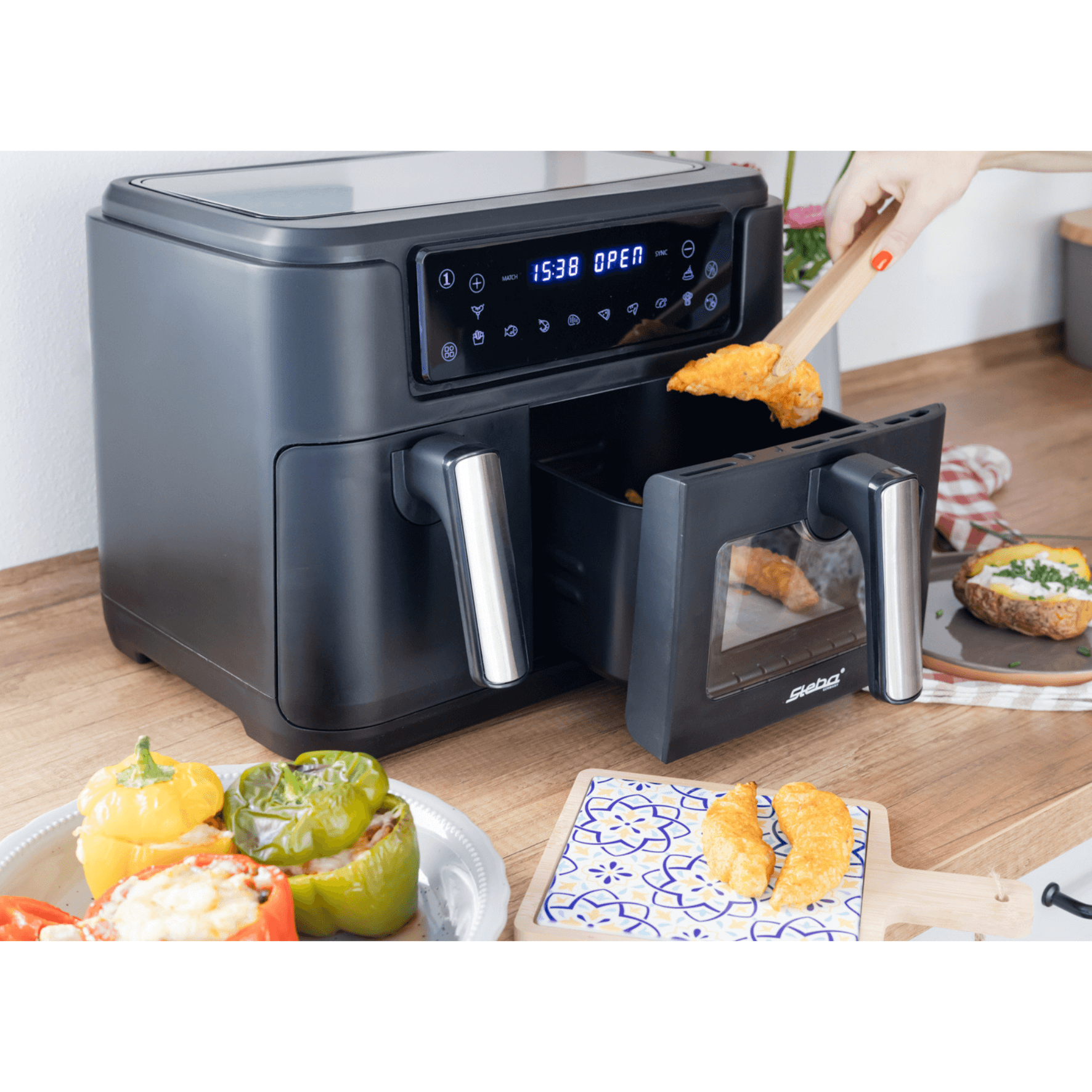 Steba HF9500 Heißluftfritteuse mit digitalem Display und zwei Frittierkammern, im Einsatz mit knusprigen Speisen und buntem Gemüse.