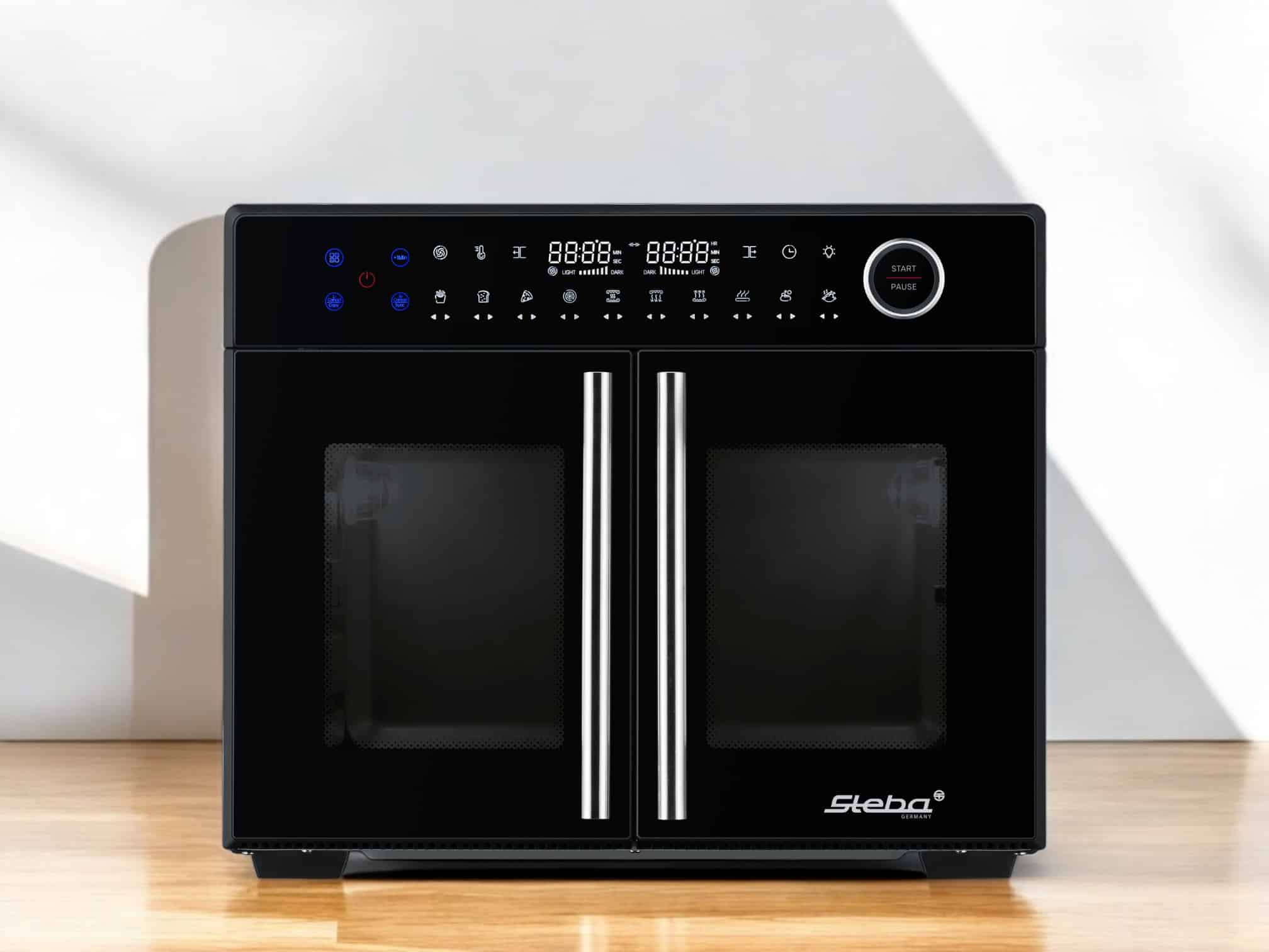 Steba Airfry-Grillbackofen AF 24 TRI-ZONE mit digitalem Display, zwei Türen und Edelstahlgriffen auf Holzuntergrund.