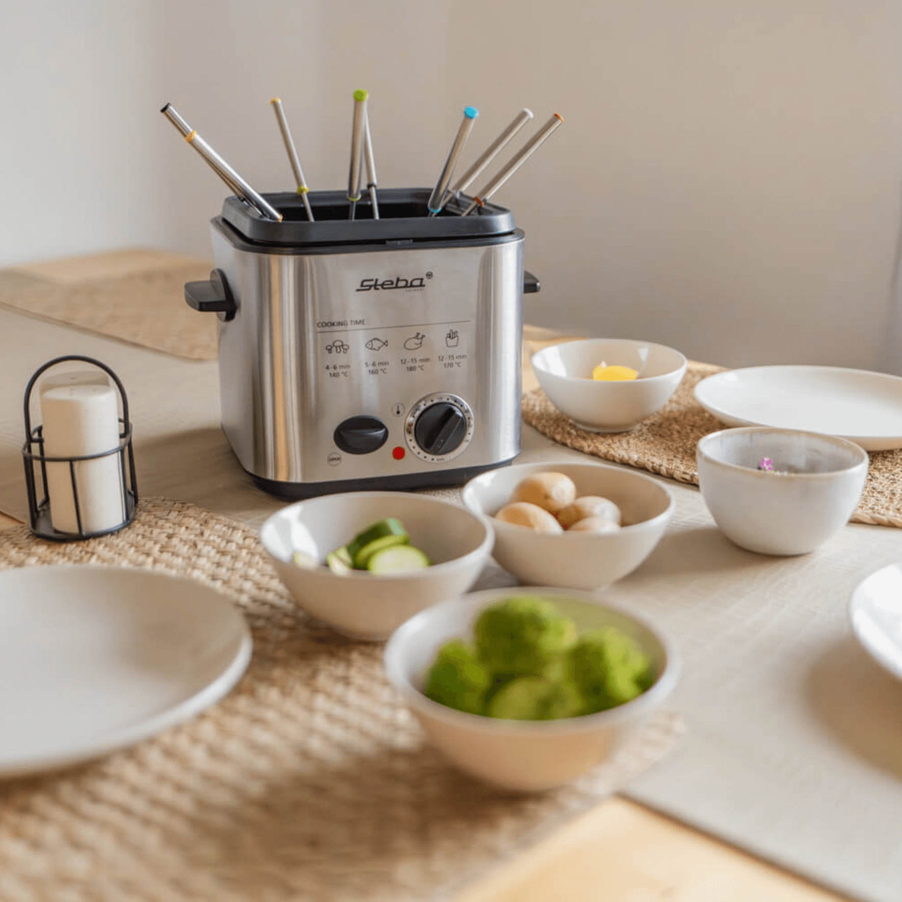 Steba DF95 Fritteuse mit mehreren Frittierstäben und Temperaturregler, umgeben von frischen Zutaten auf einem Tisch.
